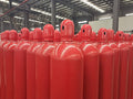 Row of red Carbon Dioxide CO2 cylinders in a warehouse setting